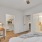 Spacious and well lit bedroom with wood floors and large windows