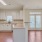 Spacious and well lit kitchen with wood floors and stainless steel appliances. 
