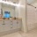 brightly lit bathroom vanity/sink counter next to shower/tub combo