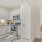 Spacious and well lit kitchen with wood floors and stainless steel appliances. 