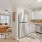 Spacious and well lit kitchen with wood floors and stainless steel appliances. 