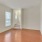 Spacious and well lit living room with wood floors and an open floor plan with access to the kitchen.