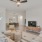 Spacious and well lit living room with wood floors and an open floor plan with access to the kitchen.